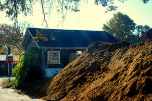 Our small, but quaint cottage peaking out behind the mounds of dirt and constant ground work.